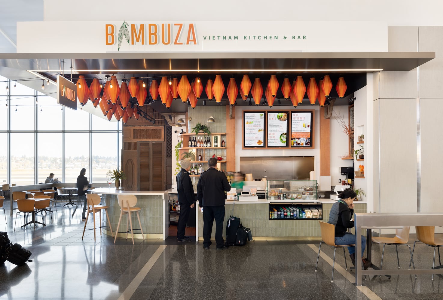 Travelers order food at Bambuza with Vietnamese-inspired decor surrounding the bar