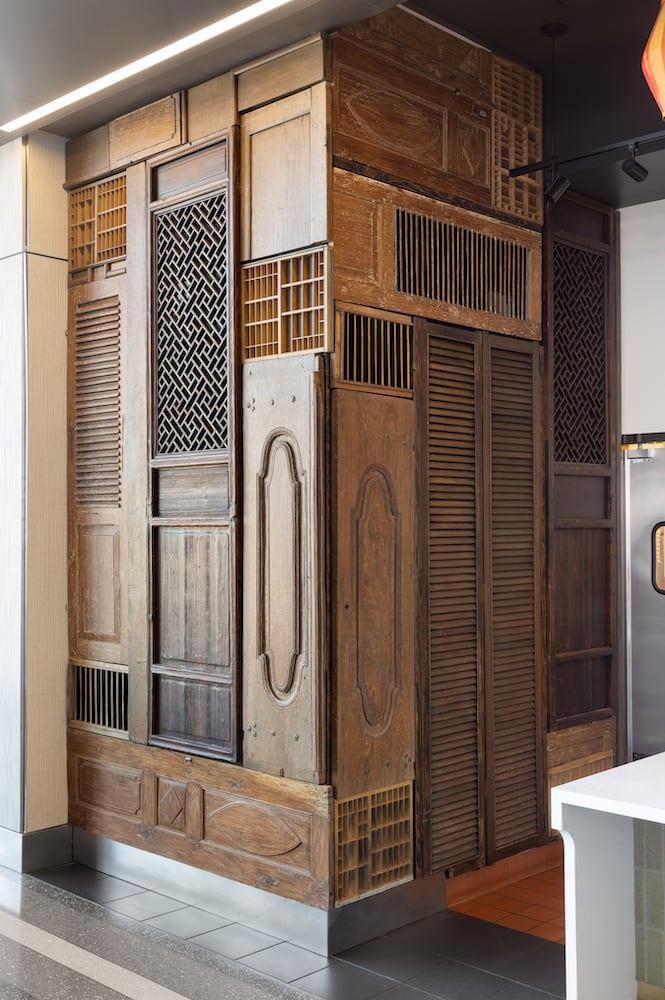 A brilliantly unique matrix of antique reclaimed doors cover the walls at Bambuza PDX