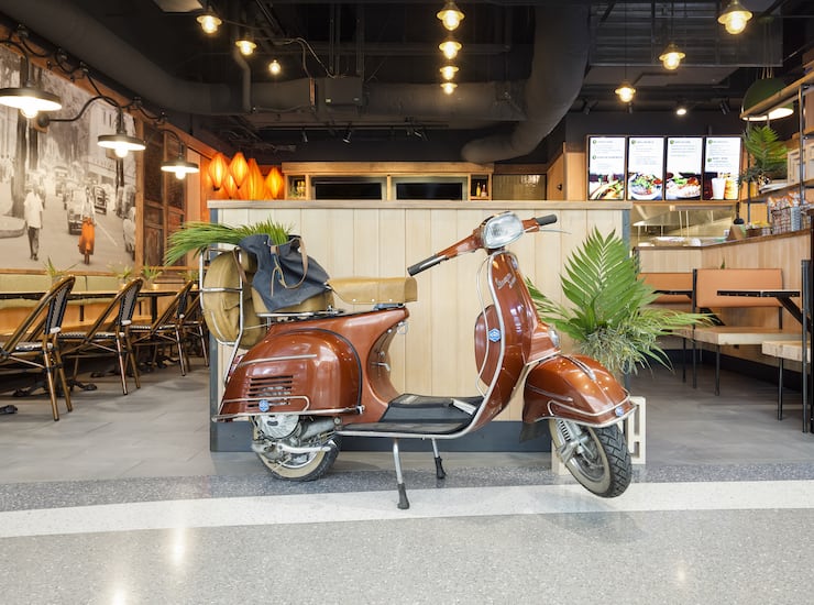 Vintage copper-colored Vespa scooter at entrance to Bambuza restaurant in Seattle