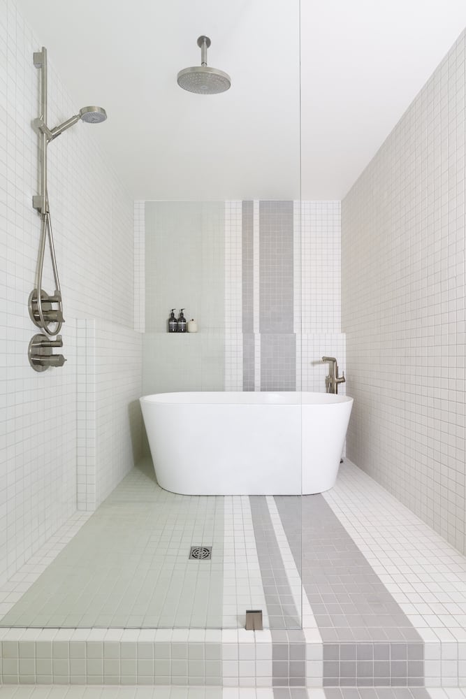 Designer bathroom walk in shower with freestanding bathtub, mosaic tile stripes