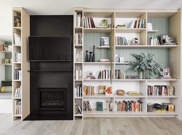 Living room bookshelves with steel fireplace and reading nook, bamboo plywood