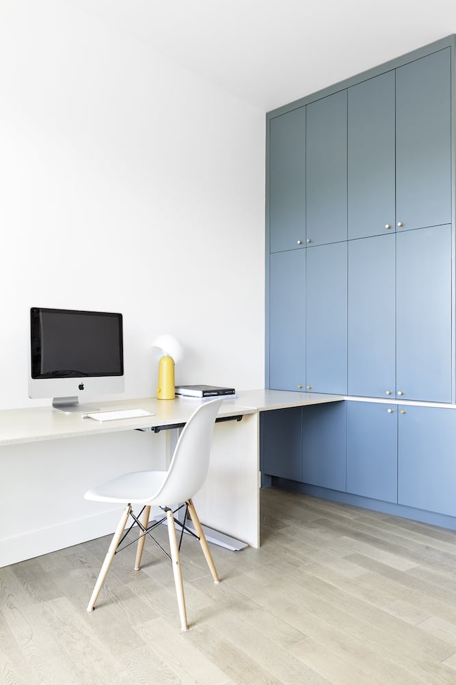 Everything room with modular standing desk, blue painted storage cabinets