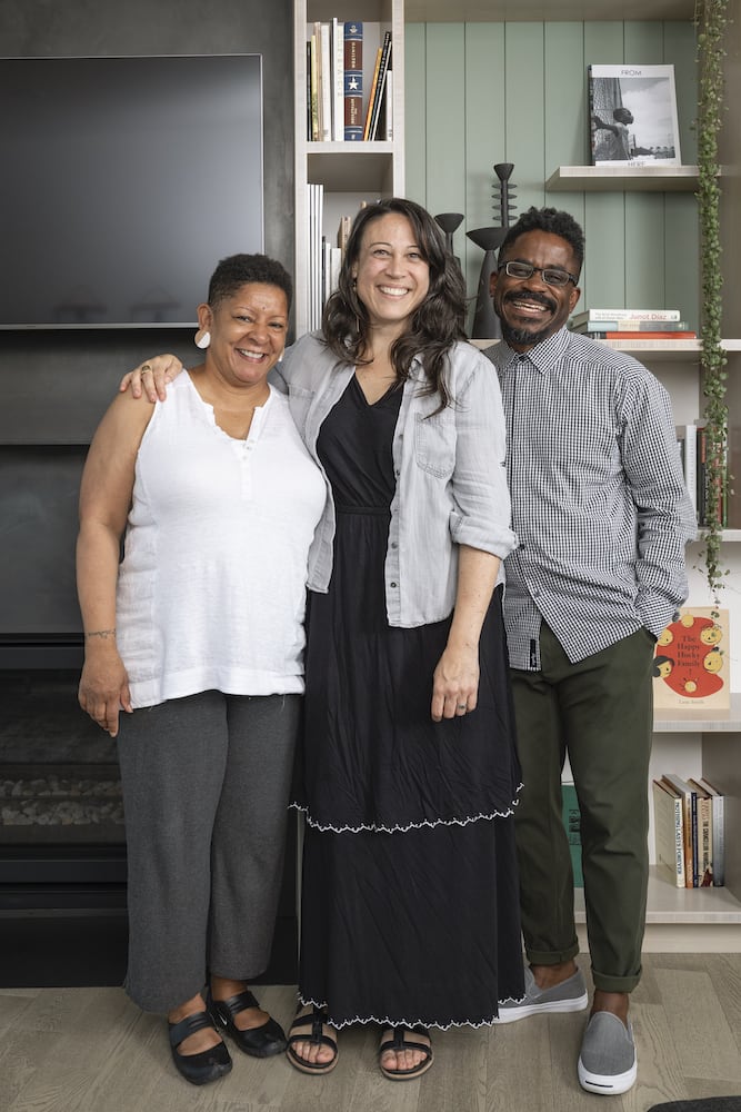 Interior Designer Stephanie Dyer with clients in front of built-in bookshelves