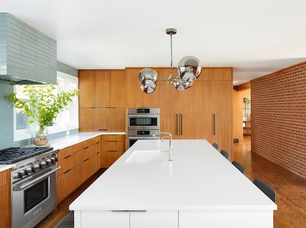 Full view of kitchen with mahogany panel-front appliances, tiled range hood