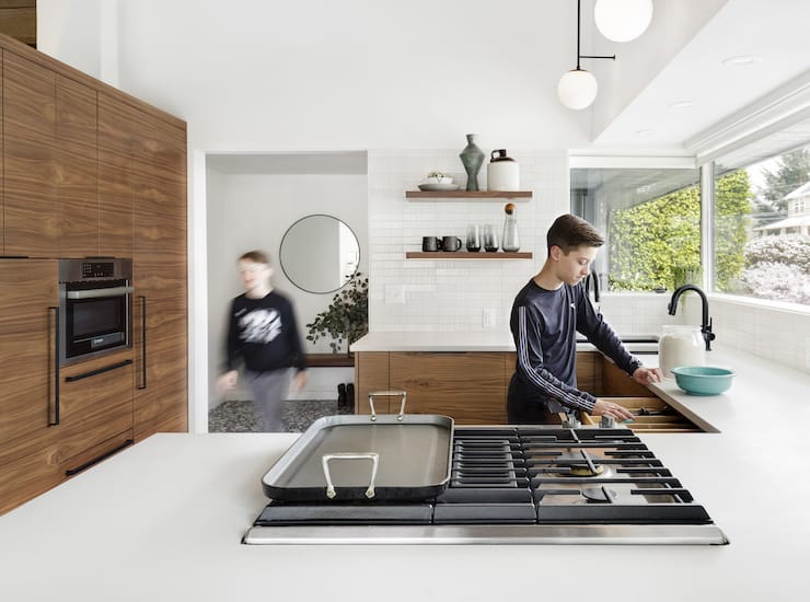 Remodeled kitchen with white quartz countertop, built-in range, and walnut cabinets