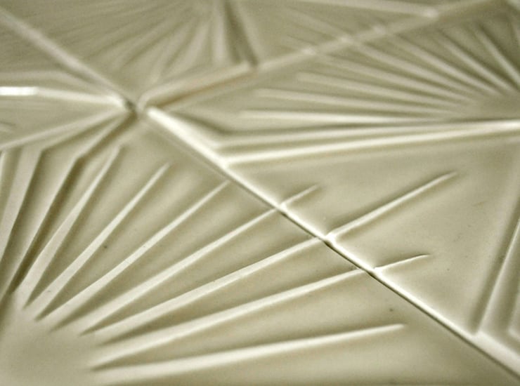 Detail of four square ceramic tiles each with different modern textured patterning