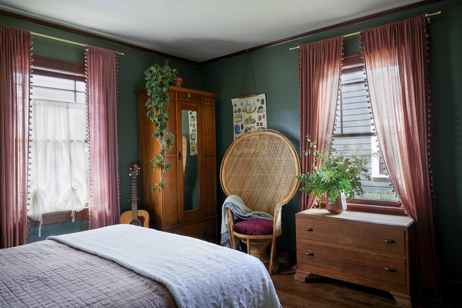 Portland bedroom with green walls, red curtains, wicker peacock chair