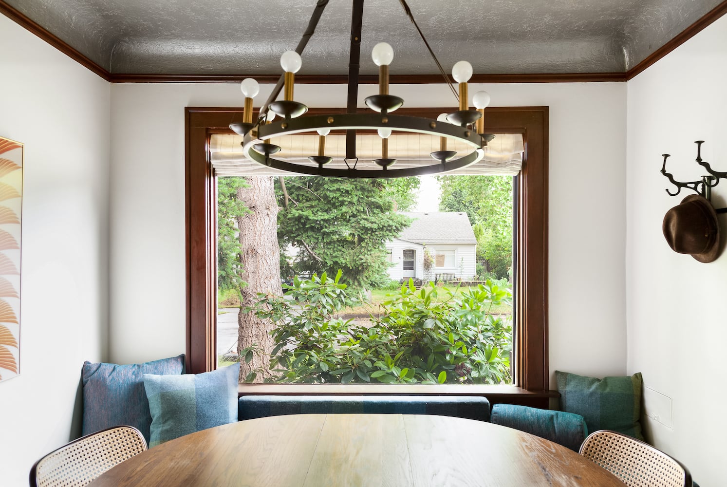 Dining area with modern chandelier, hat rack, built-in bench, large window