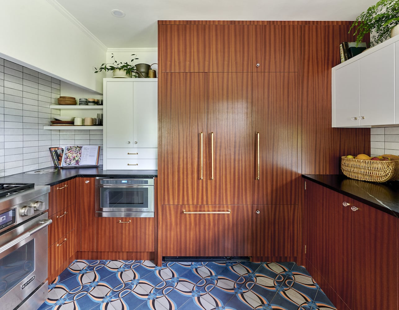 Kitchen with sapele cabinets, patterned floor tile, panel fridge, appliances