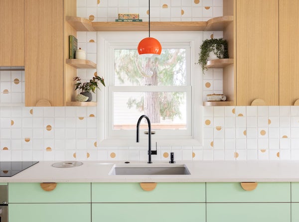 Angle of kitchen counter with built-in Bosch rangetop and wall oven, green cabinets
