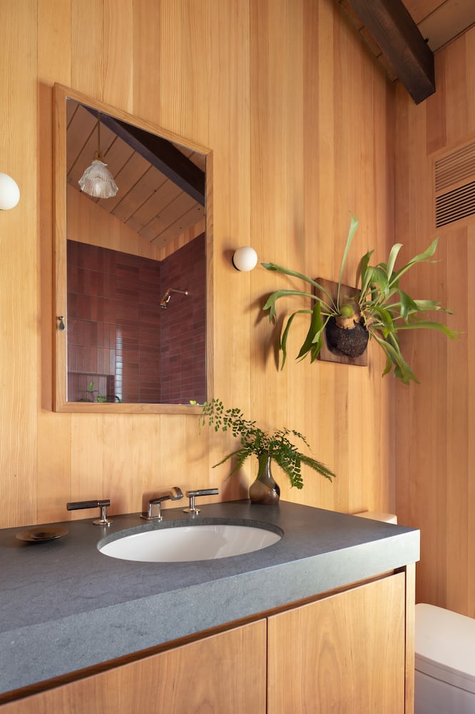 Bathroom renovation vanity with honed basaltina slab and mirror, fir walls and vent