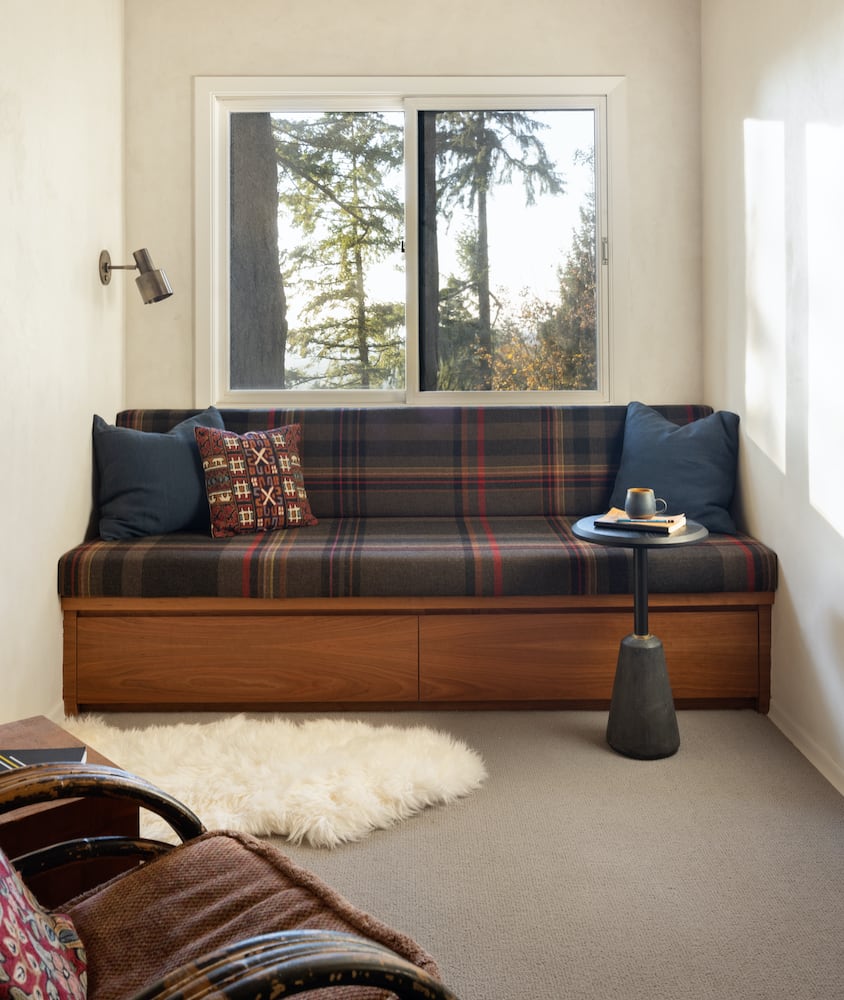 A custom reading bench with plaid cushions in an upstairs mezzanine cabin remodel