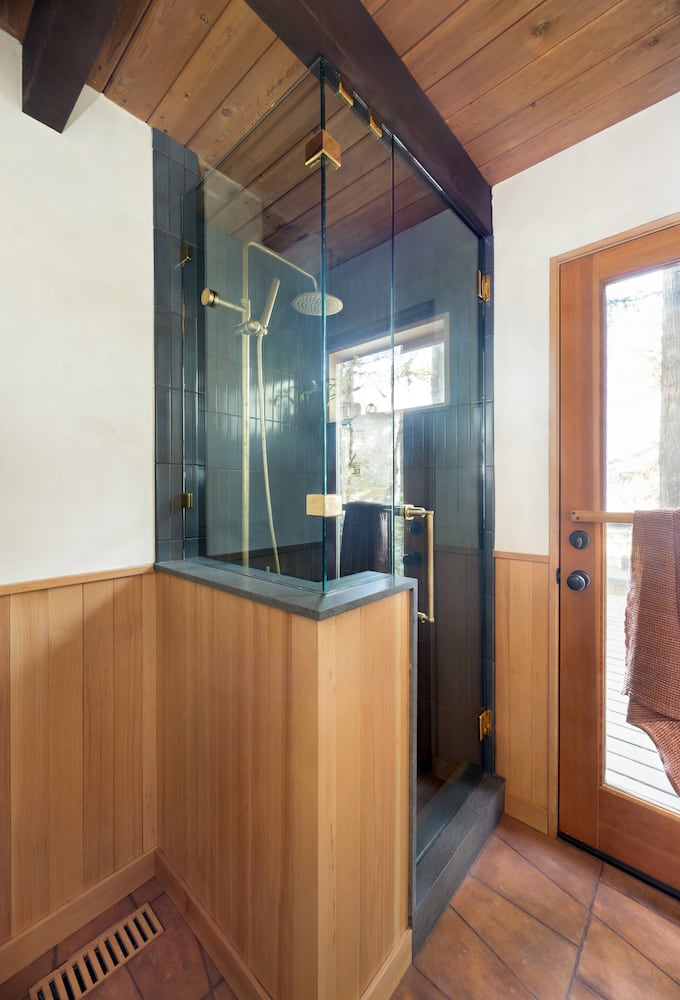 Glass and wood-paneled shower design from the outside with original wood ceilings