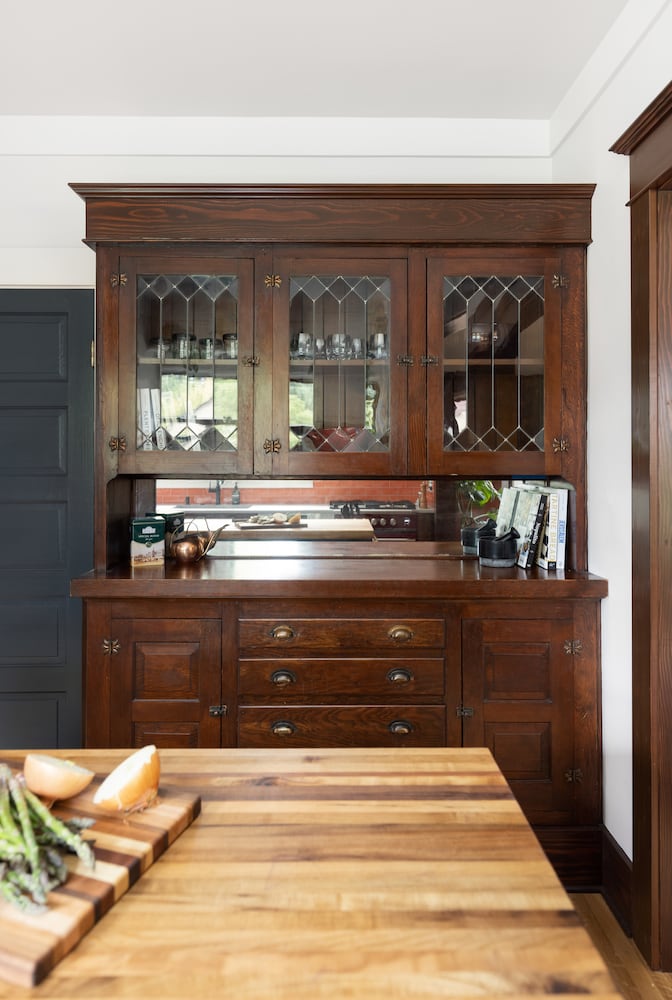 Restored built-in bar area with dark cherry wood and leaded glass pattern cabinet doors