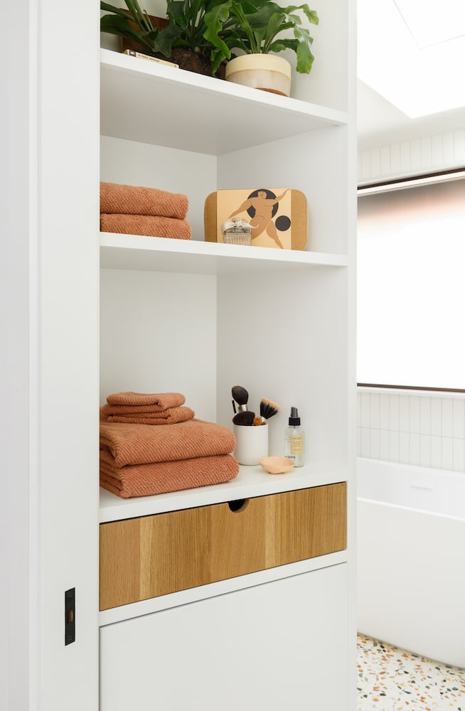 Interior bathroom view with custom designed shelving, white oak drawer, terrazzo