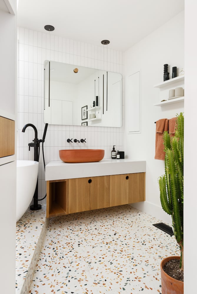 Bathroom with terrazzo floor, floating oak cabinetry and concrete vessel sink