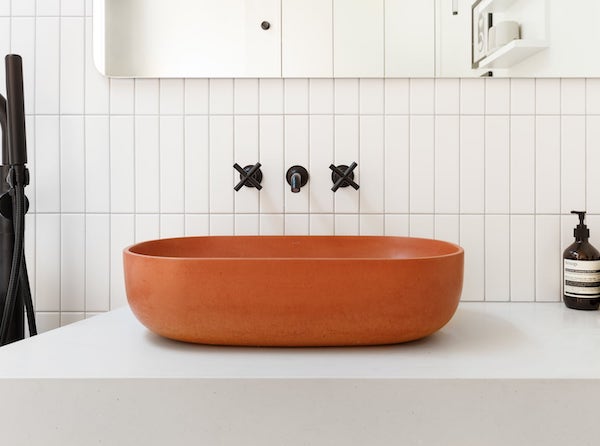 Concrete vessel sink with cross handle wall mounted black fixtures, white tile