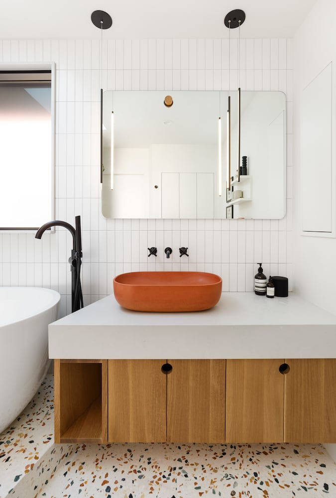 Bathroom remodel with colored terrazzo floor, floating oak cabinet, vessel sink
