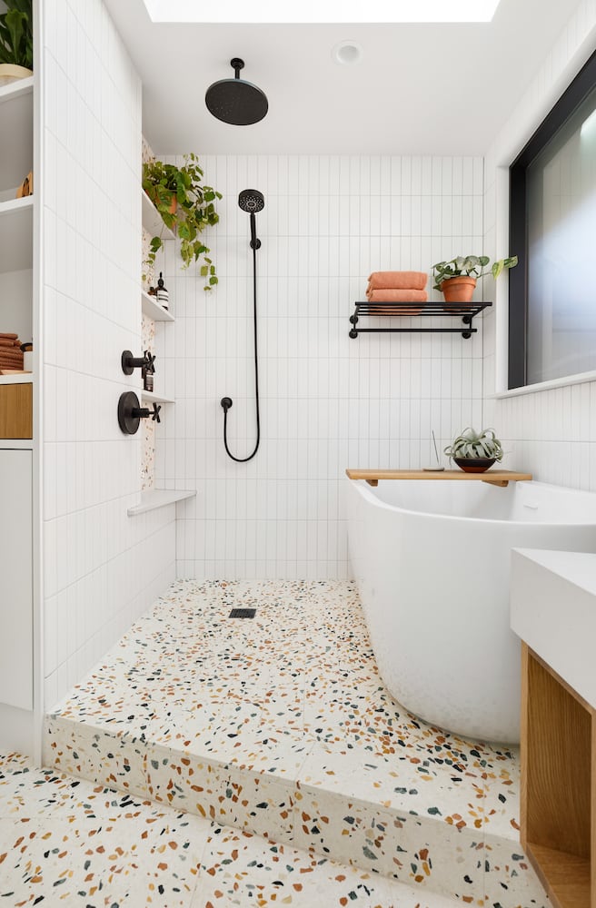 Walk-in shower in angled floor plan bathroom, freestanding tub, skylight