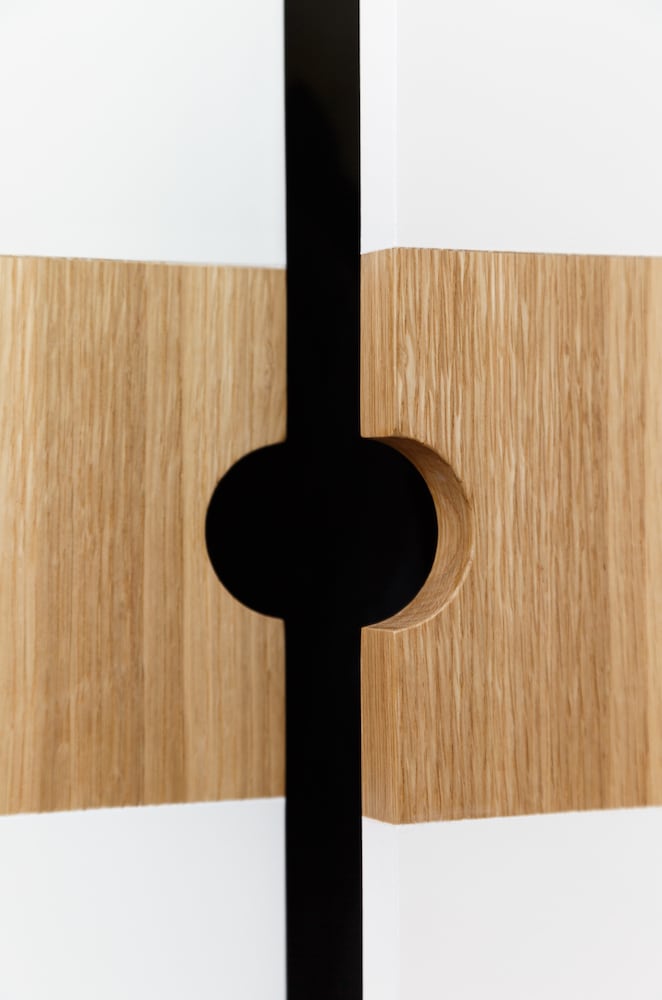 Detail of custom white oak wardrobe door trim with painted white doors