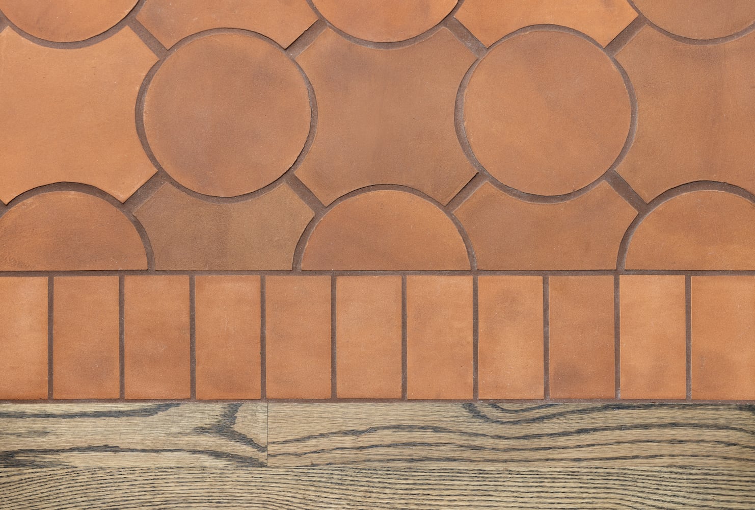 Expertly executed seams between wood flooring and tierra Mexican floor tile