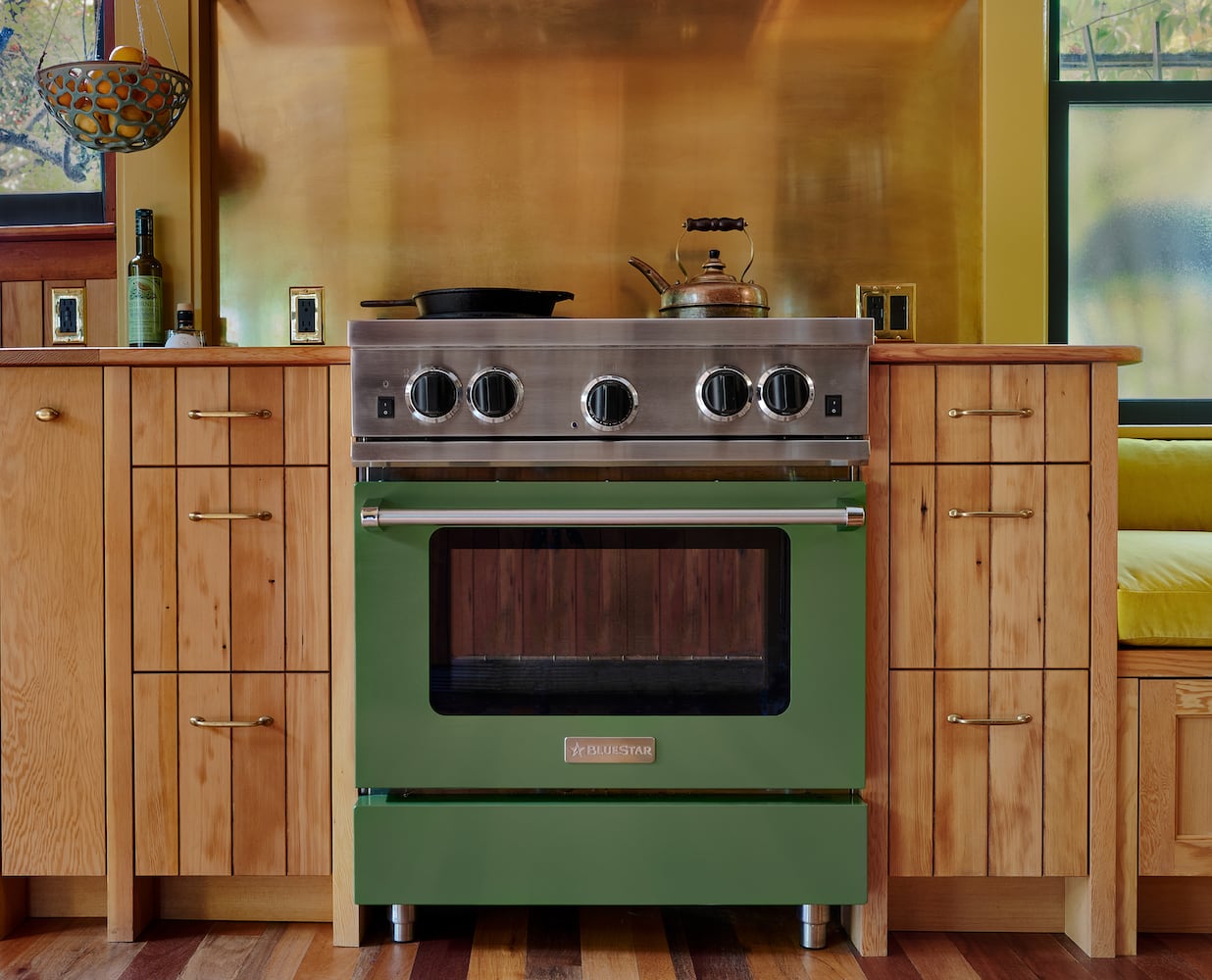 Perfeclty fitted BlueStar cooking range, wood paneled drawers, brass backsplash