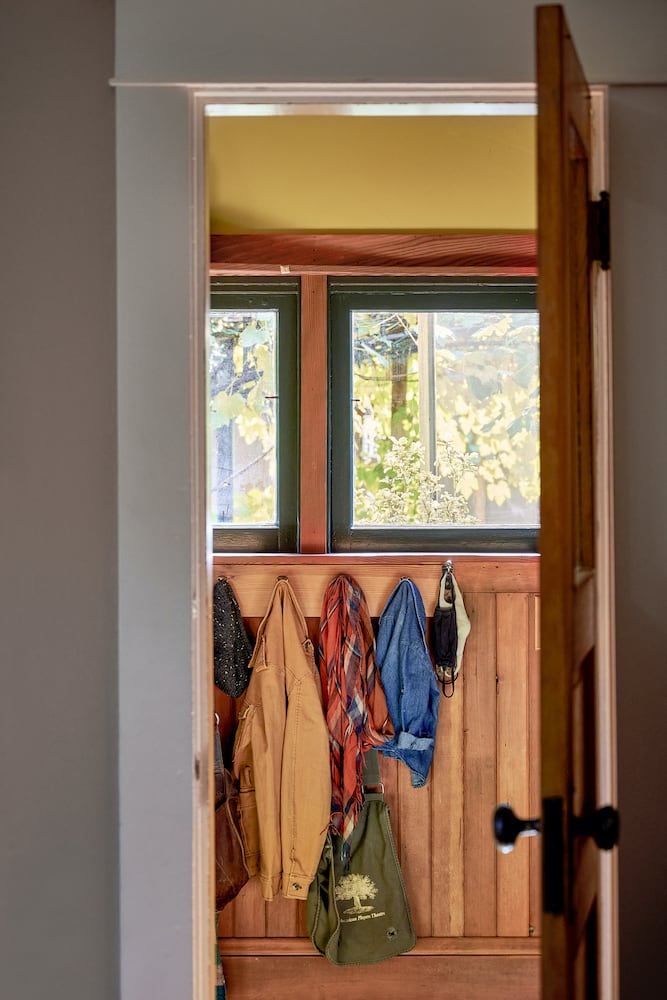 Waist-level horizontal coat rack under windows with wood slat trim, space planning