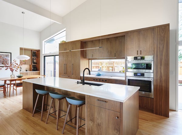 Remodeled kitchen with walnut cabinets, island with white quartz counters 