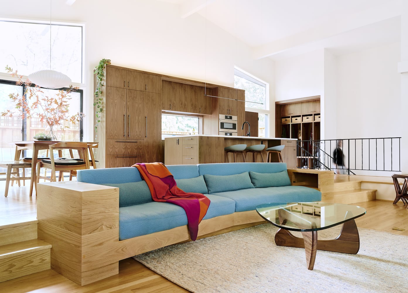 Midcentury modern recessed living room with built-in oak sofa, wood floors