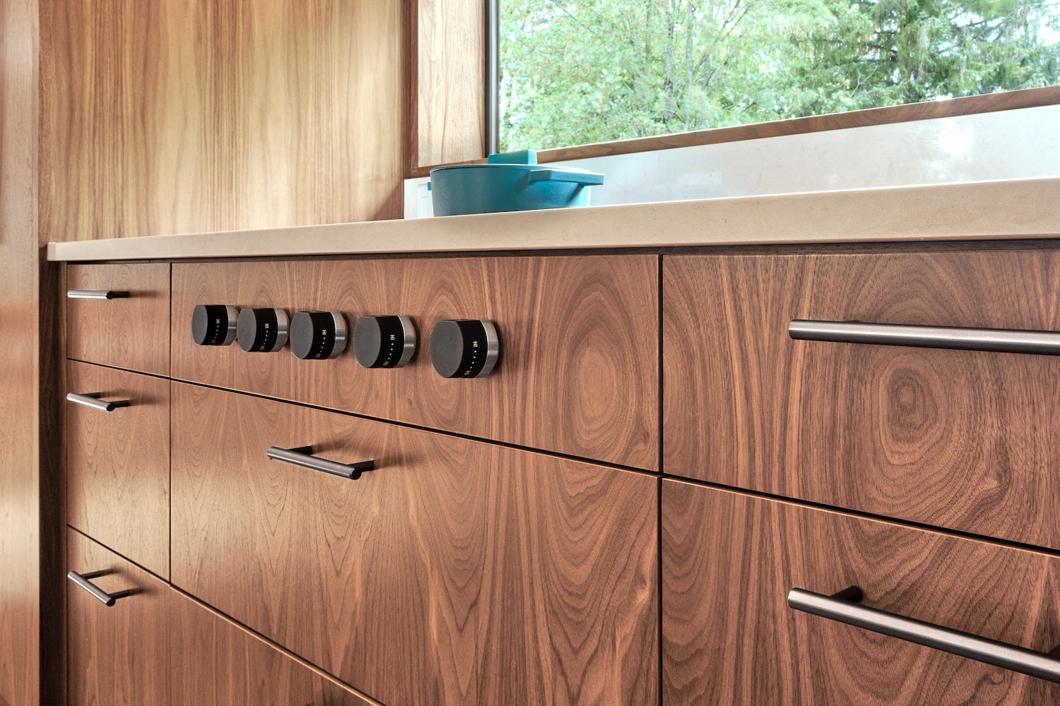 Wolf cooktop integrated inside of custom walnut cabinetry, stainless hardware