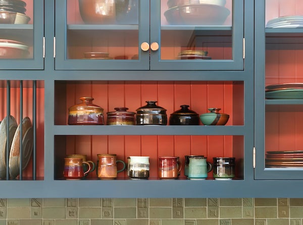 Kitchen painted cabinet with shelving for handmade ceramics, plate rack, glass doors