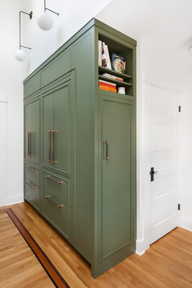 Kitchen green cabinets, panel front fridge, pantry, broom closet closed, wall sconce