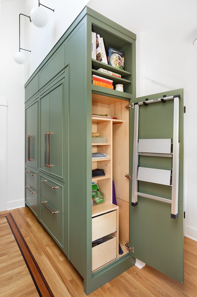 Kitchen green cabinets, panel front fridge, pantry, broom closet open, wall sconce