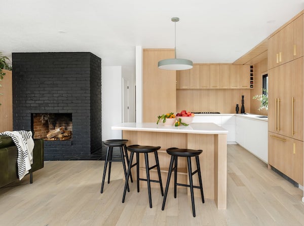 Modern house living room with black fireplace, kitchen with pentagon island