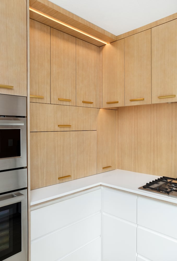 Modern light wood kitchen appliance garage with wood backsplash