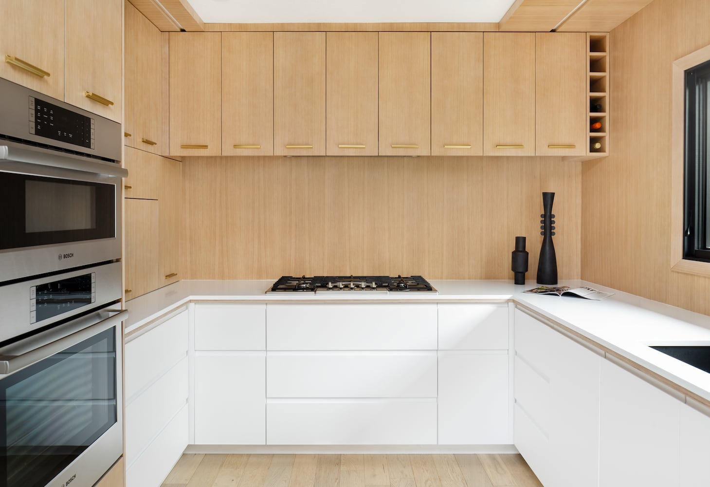 Modern light wood kitchen with white cabinets and wood backsplash