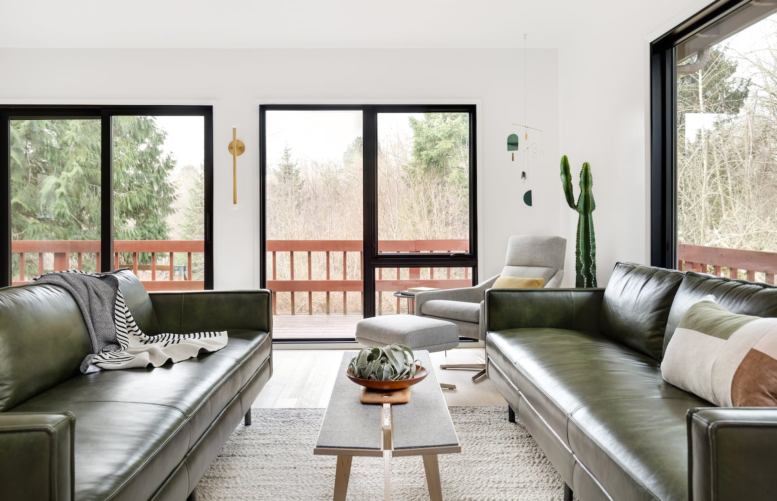 Portland, Oregon modern house living room with green leather sofas and view of trees