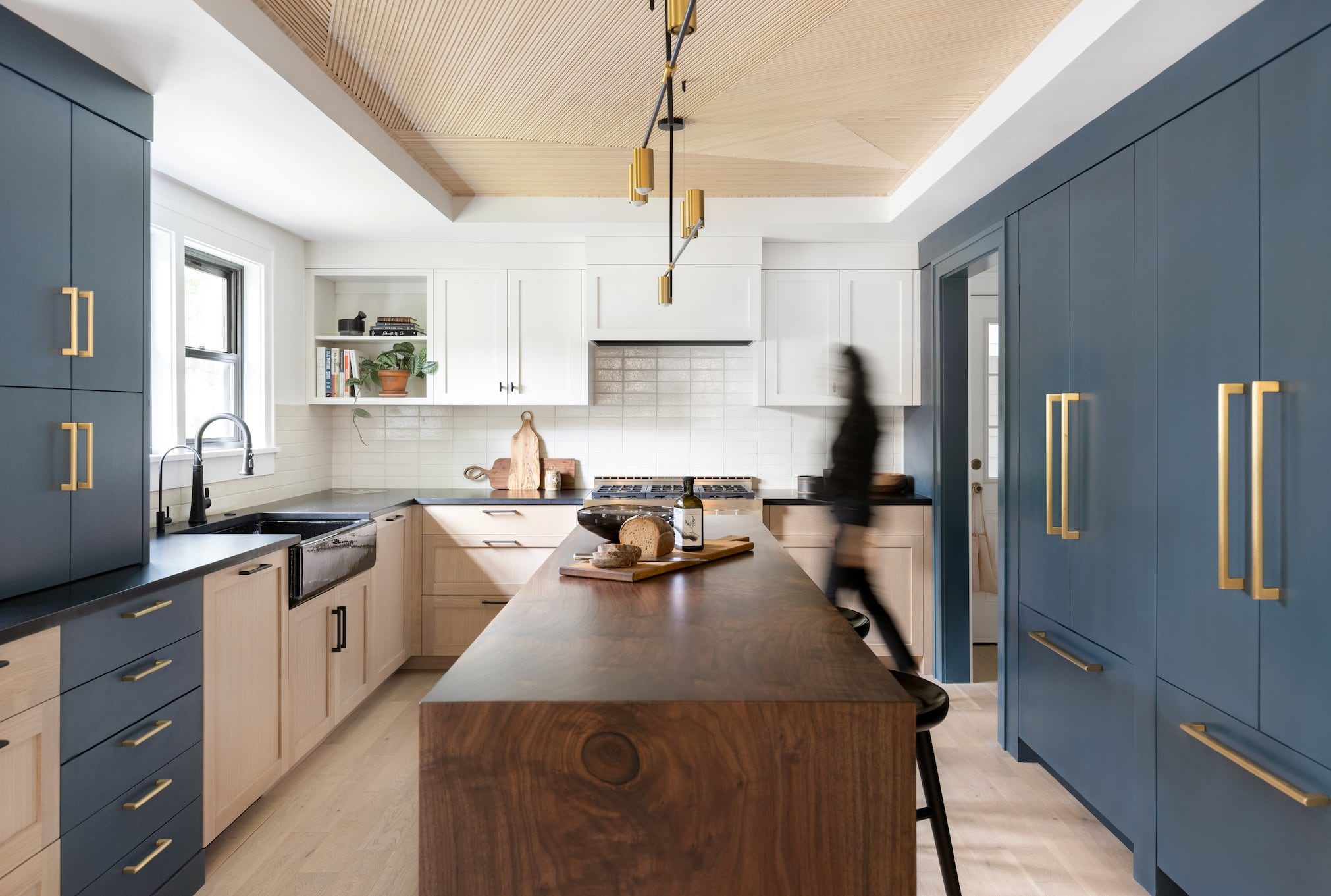Redesigned Portland kitchen with black apron sink, blue cabinetry, walnut island