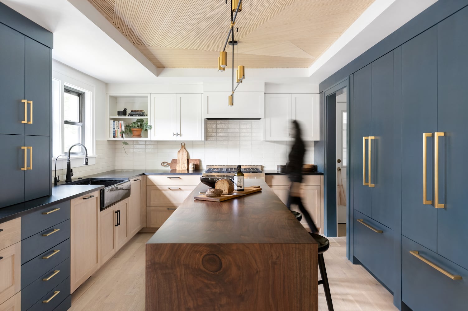 Redesigned Portland kitchen with black apron sink, blue cabinetry, walnut island