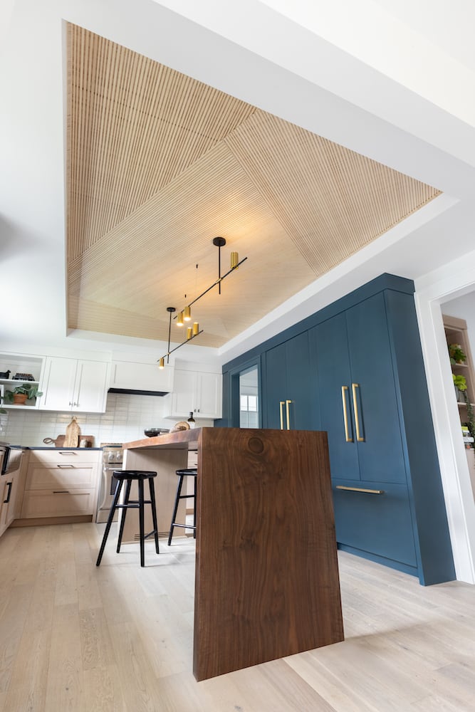 Upward view of incredible custom geometric wood kitchen ceiling with handpicked lighting