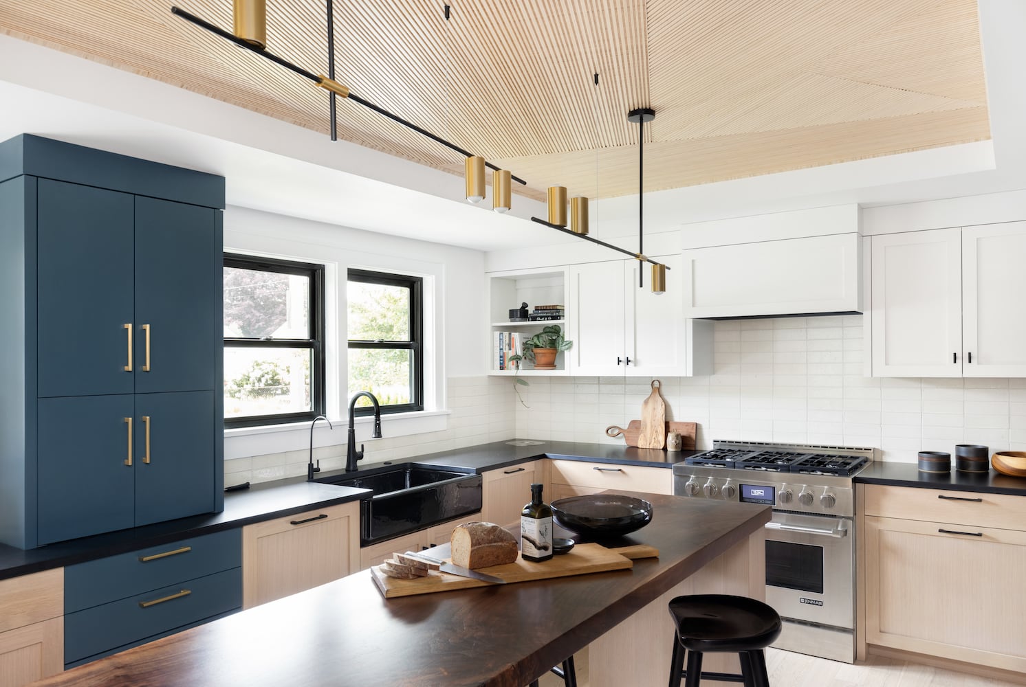 Portland kitchen with walnut island, muted blue Ikea cabinets, Kohler black apron sink
