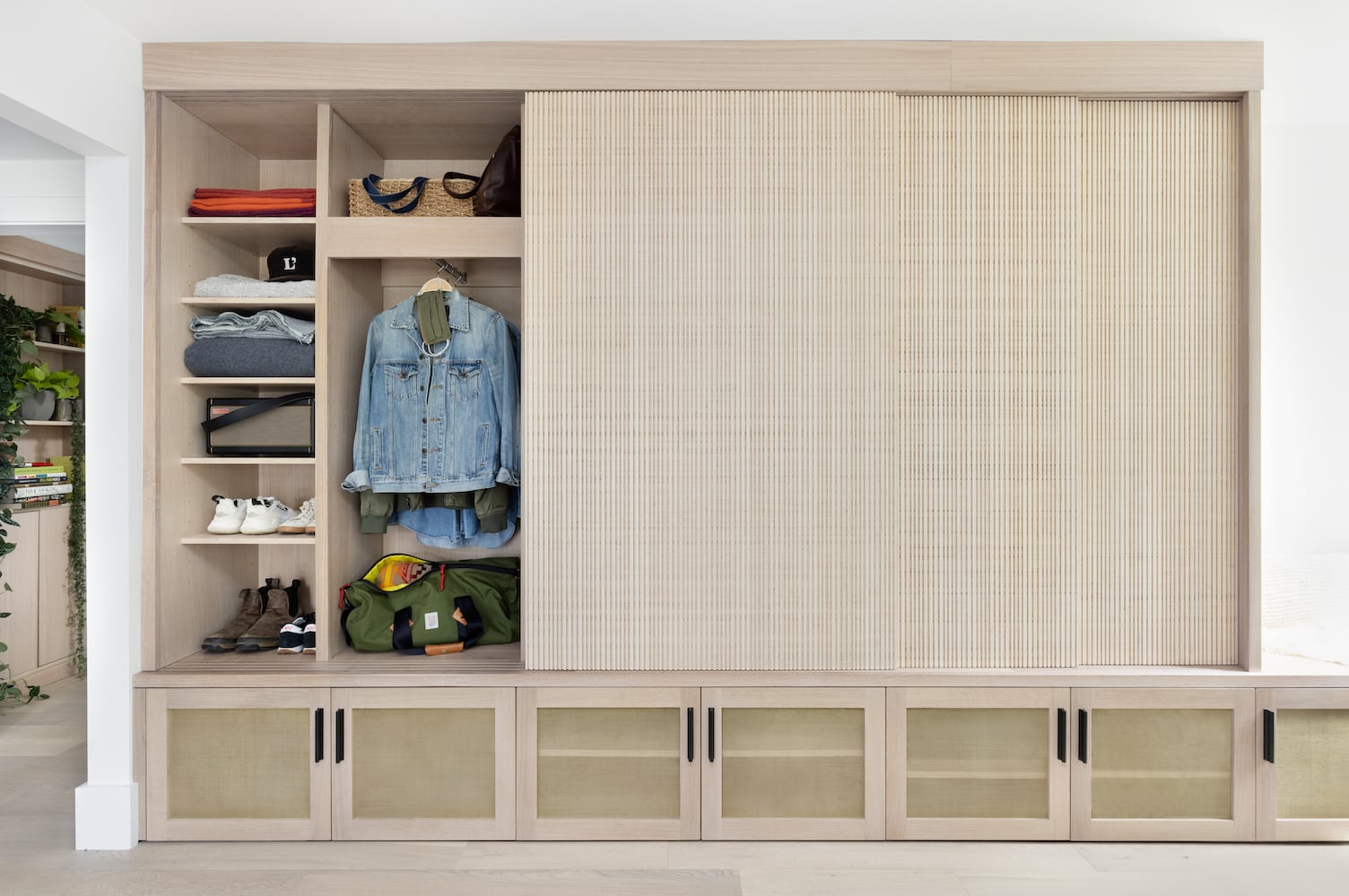 Custom casework housing clothing and linens behind textured bamboo sliding doors