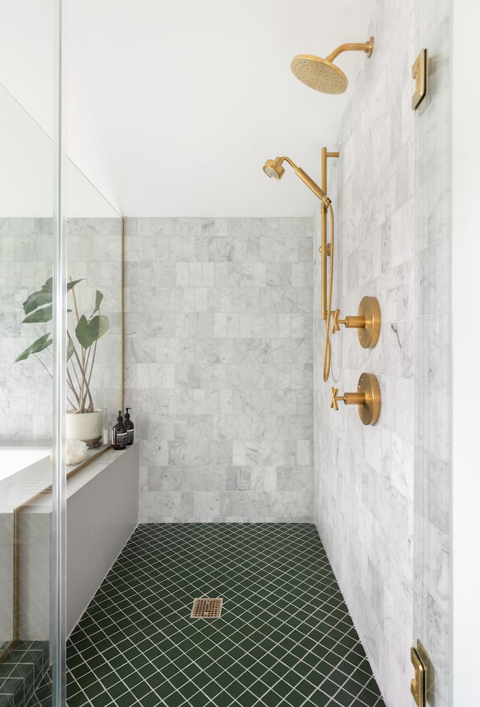 Enclosure shower designed around bathtub, gold fixtures, cross handles, hnd shower