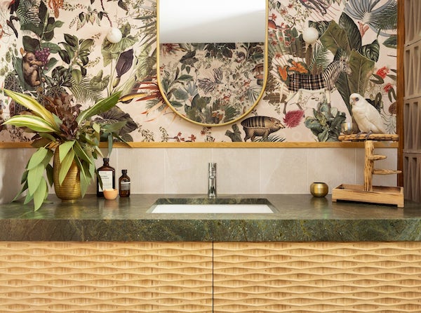 Funky bathroom vanity with green granite countertop, tropical wallpaper, bird perch
