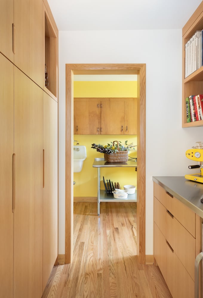 Pantry hallway renovation leads to a laundry room with bright wood floors and panels