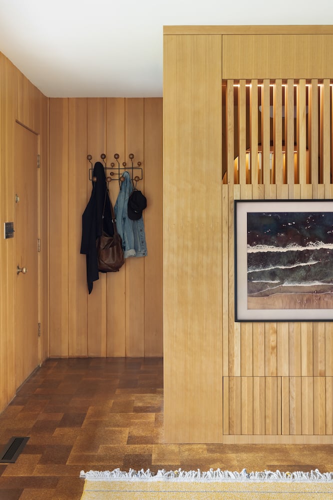 Entry way to midcentury modern home with coat rack, fir trim details to match walls